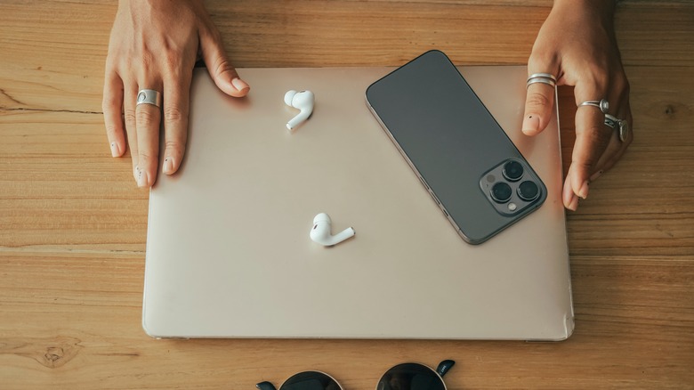 iPhone on table with laptop and earphones