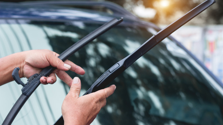 A person holding car windshield wiper blades