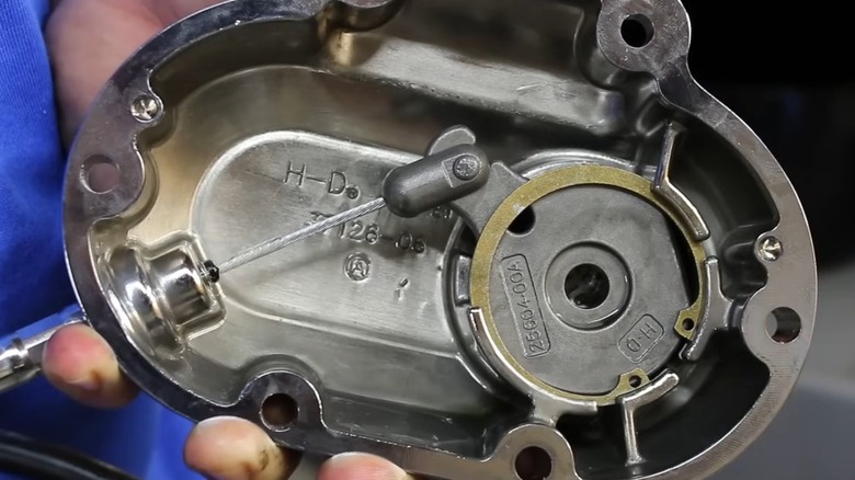 A person holding a disassembled Harley clutch