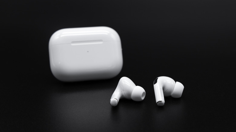AirPods Pro 2 with their case in front of a black background
