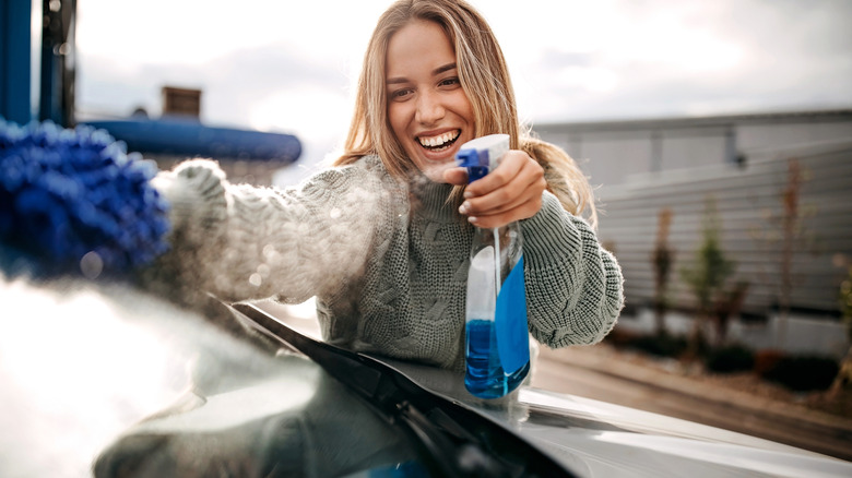 Woman cleaning car window