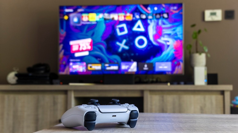 DualSense controller sitting on table in front of TV