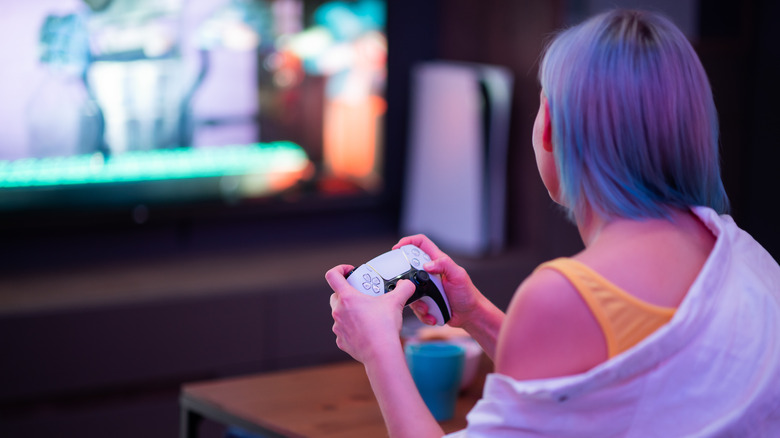 Person playing PlayStation 5 games sitting on a couch