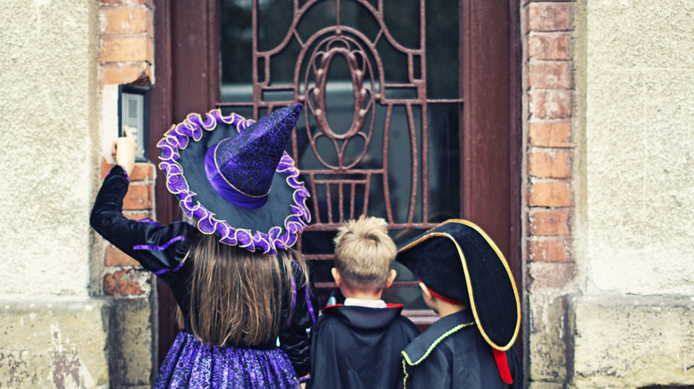 kids in costumes pressing doorbell
