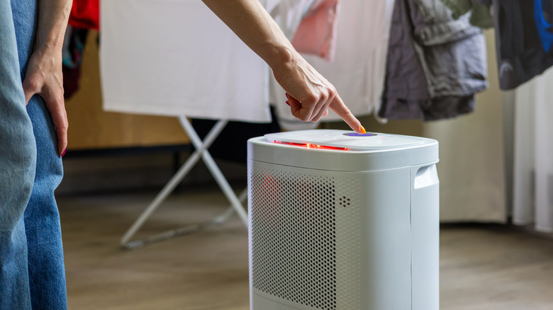 A person turning on a dehumidifier