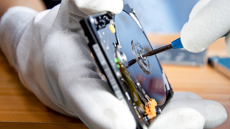 hands repairing a hard drive