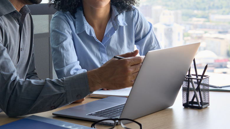 man and woman using laptop