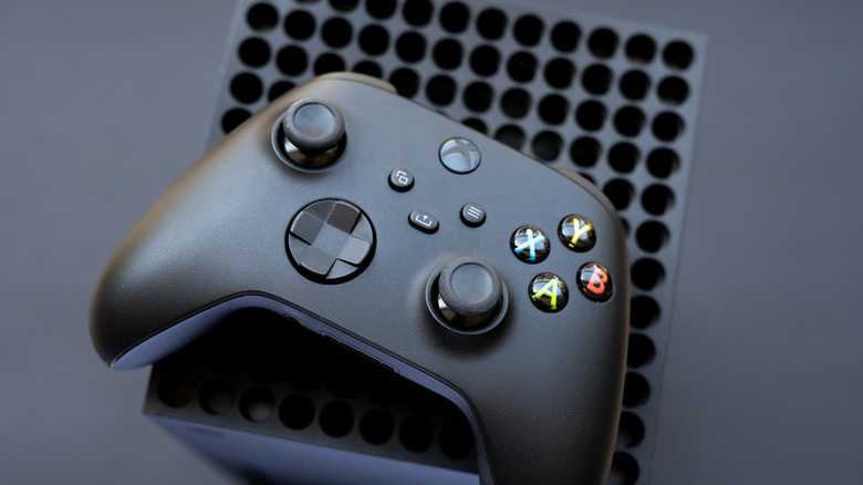A Xbox Series X controller on top of a console