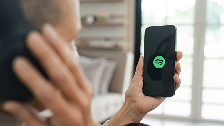 Person holding phone showing Spotify logo