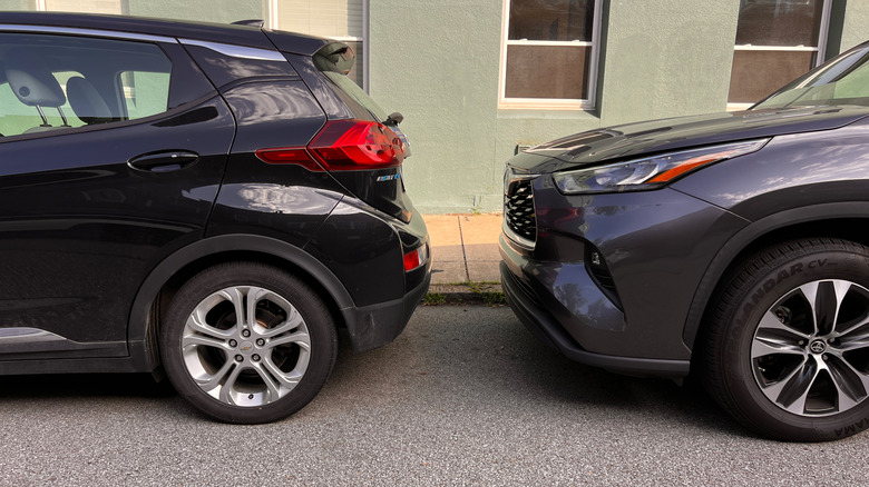 Two cars parked closely on the street