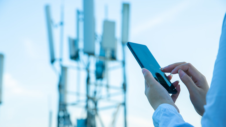 Person using phone near tower