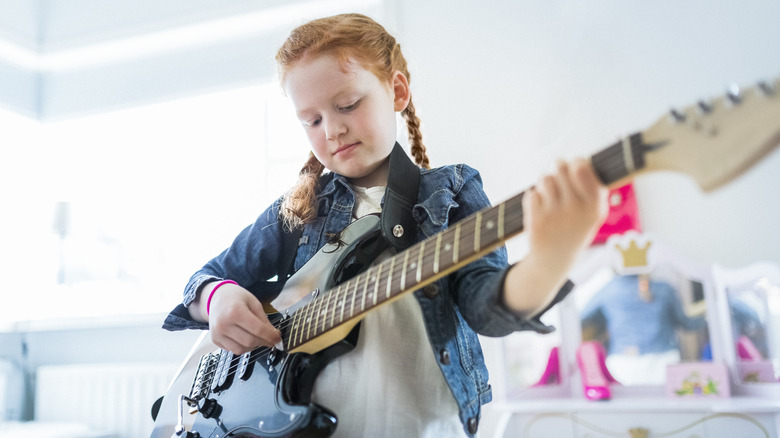 young girl playing electric guitar