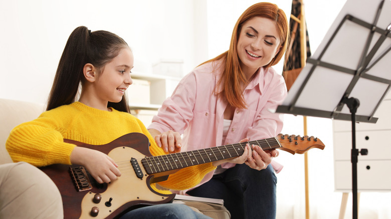 guitar student with her teacher