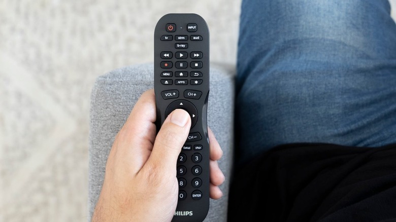 Person holding a Philips remote
