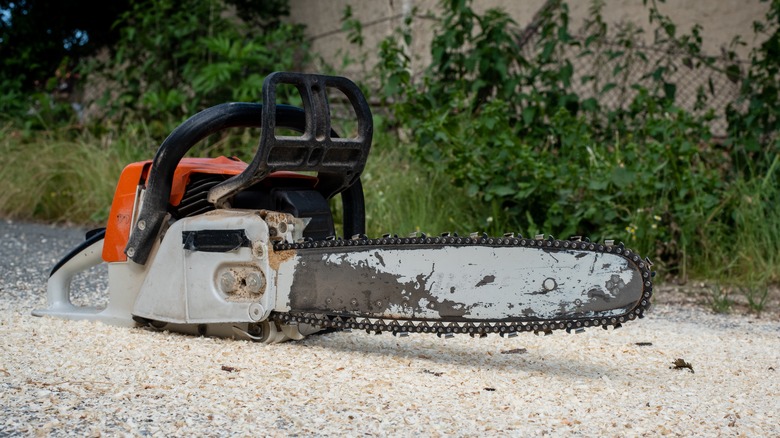 A Gas-Powered Chainsaw Sitting On The Ground