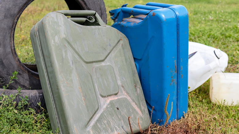 green and blue gas canisters near trash