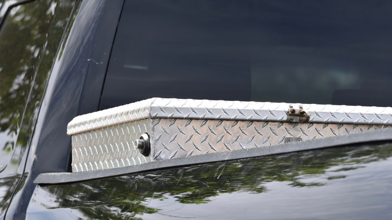 A off-center close up shot of a metal crossbed tool box on a pickup truck.