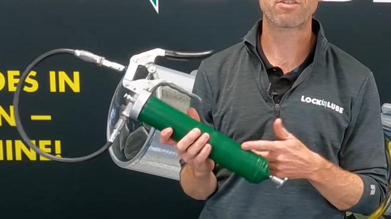A demonstrator holding a grease gun