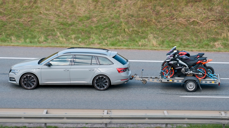 Audi station wagon towing a small trailer with two bikes strapped down