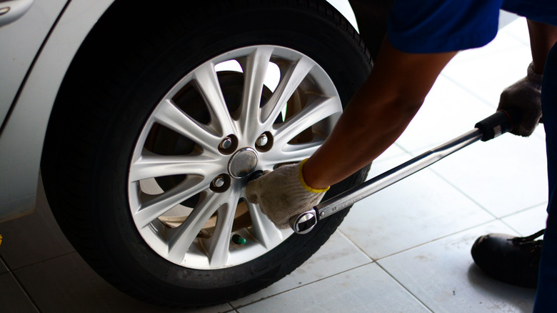 Person using click torque wrench to tighten lug nuts