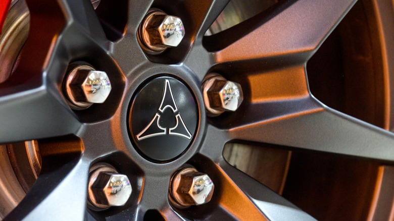 Closeup of five lug nuts in center of wheel