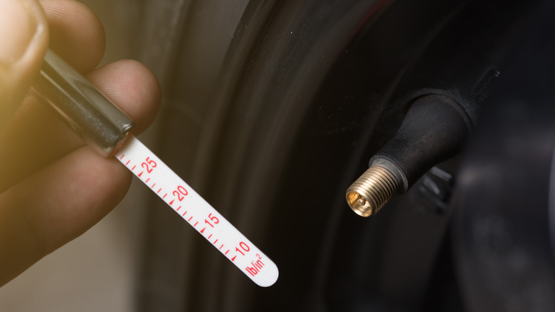 A man checking the tire pressure with a gauge