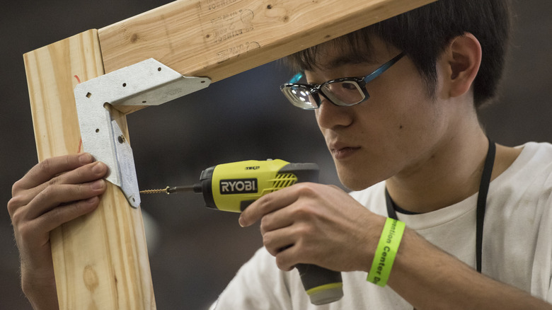 Person drilling screw into wood