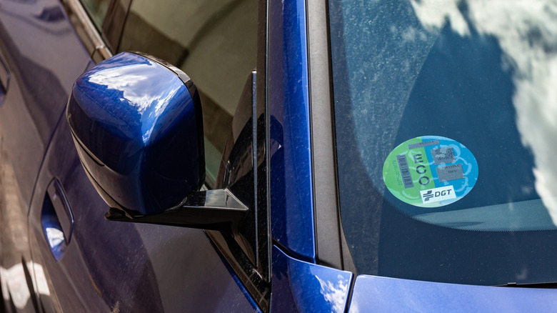 Blue car with a sticker on the front windshield