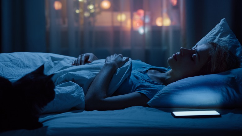 Woman sleeping with phone lit up