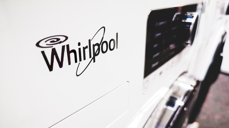 Close up to a Whirlpool brand logo on a white washing machine