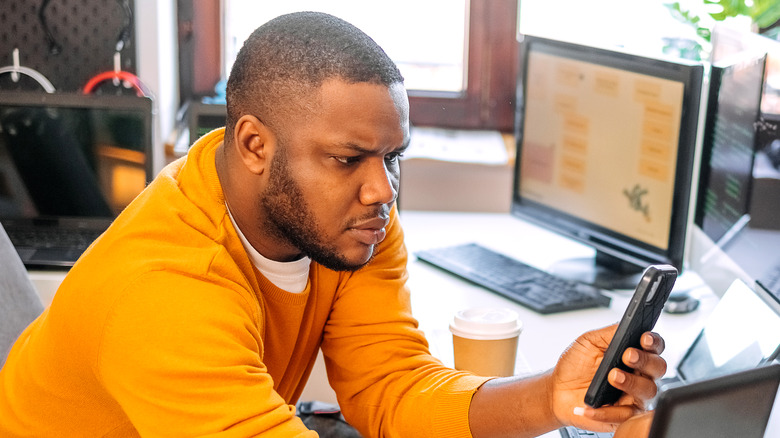 man using iphone and pc