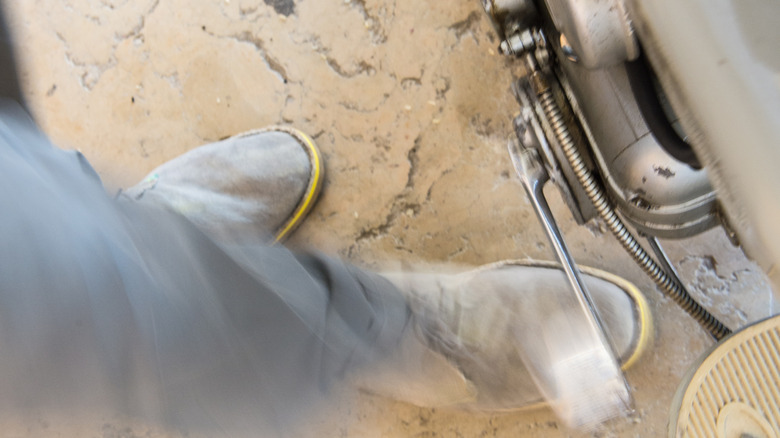 Blurry slow shutter speed shot of a feet kickstarting a motorcycle