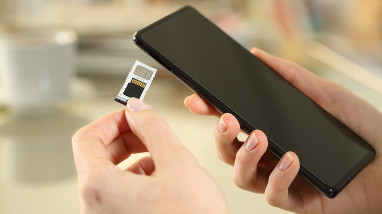 Person inserting SD card into phone