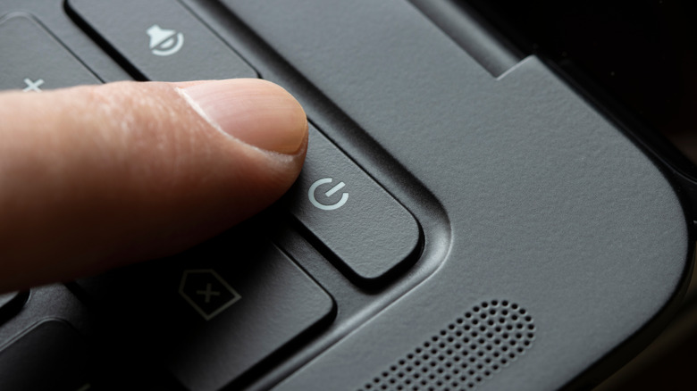 finger hitting the power button