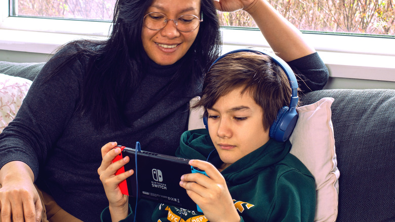 Parent watching child play Nintendo Switch