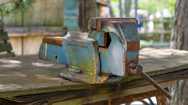 A weathered bench vise in a shed.