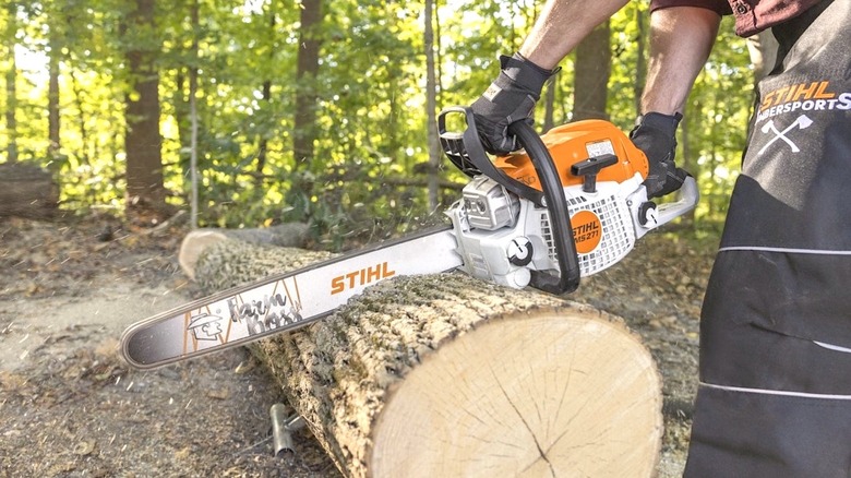 Person using Stihl Chainsaw to cut wood