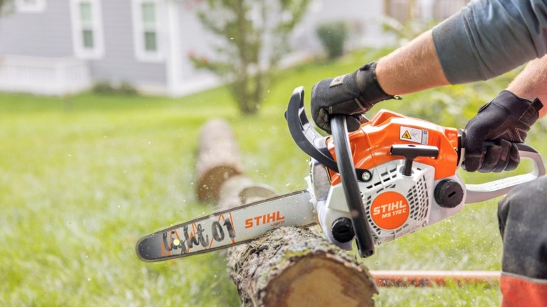 Person using Stihl Chainsaw to cut wood