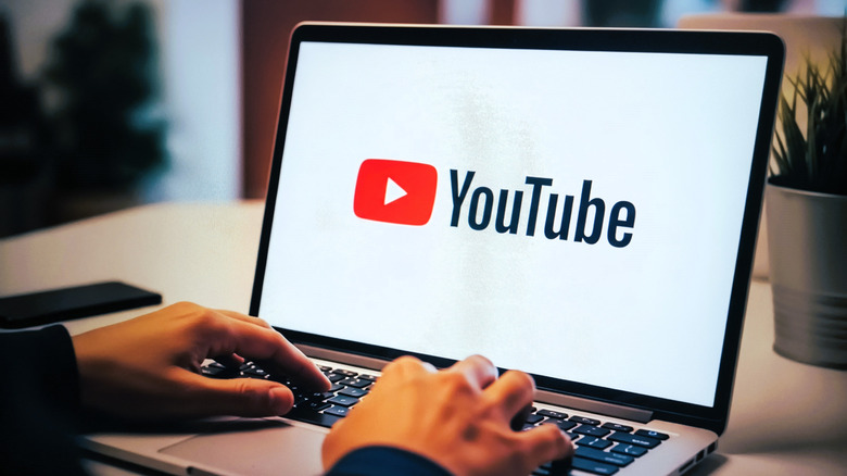 A person on a laptop computer with YouTube on the screen