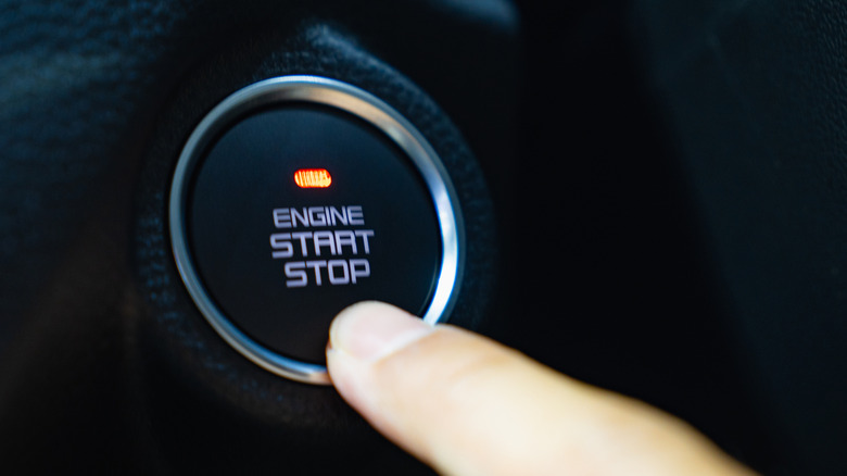 Finger reaching for a push-start button