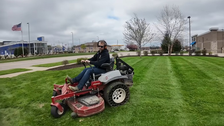 A man on a zero-turn mower demonstrating a K-turn or three-point turn.