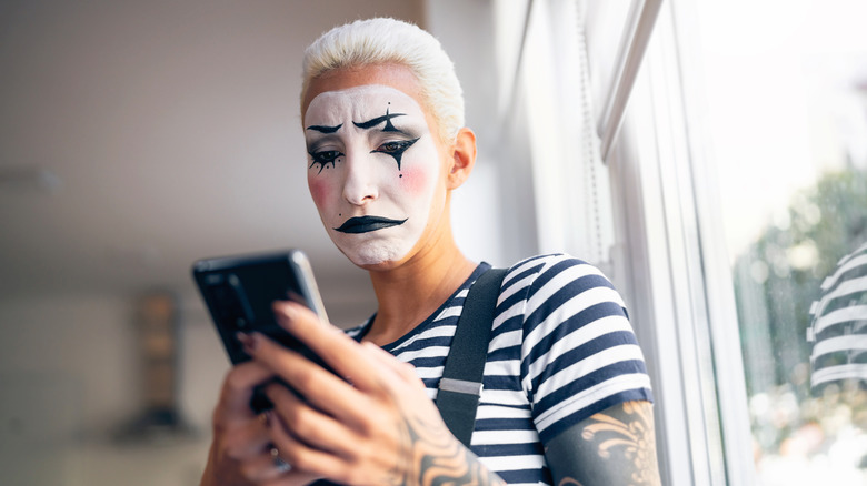 mime frowning at smartphone