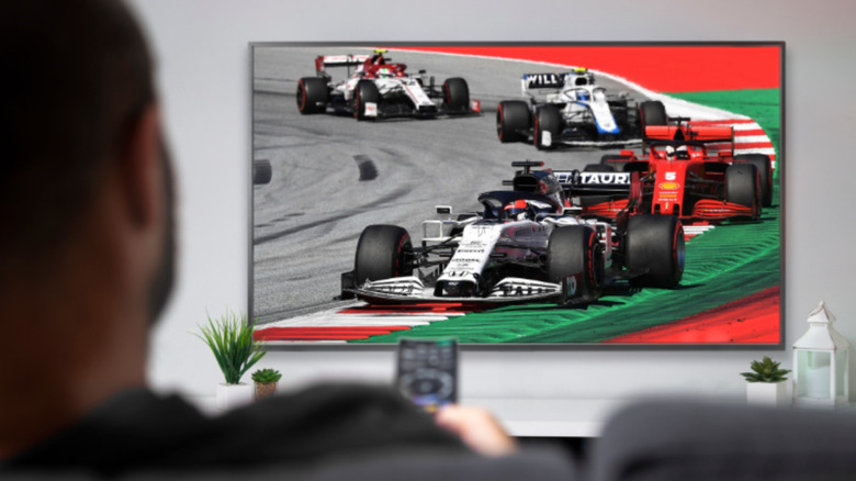 man watching Formula 1 races on TV