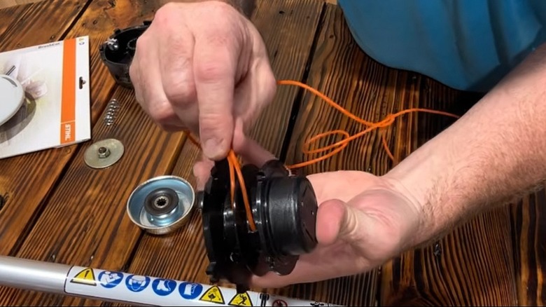A man demonstrating how to restring an 27-2 C trimmer head from STIHL