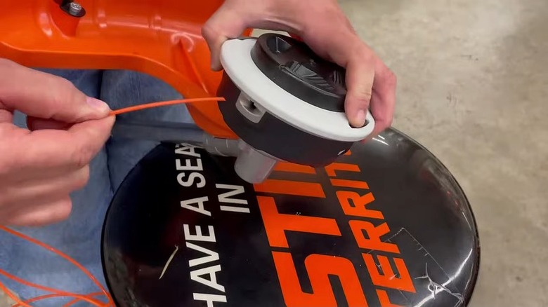 A man demonstrating how to restring a STIHL Easyspool type trimmer head