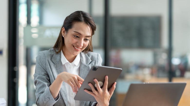 A smiling woman using an iPad