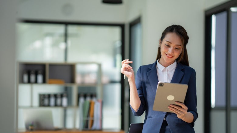 Woman standing while holding iPad