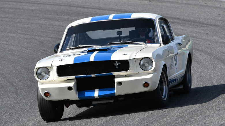 Front 3/4 view of 1965 Shelby Mustang GT350 cornering in trackside setting