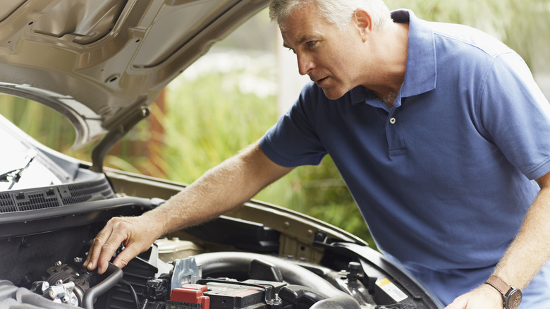 Person works on car engine