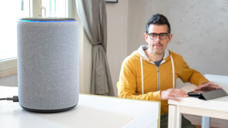 Man staring at and using an Amazon Echo device.
